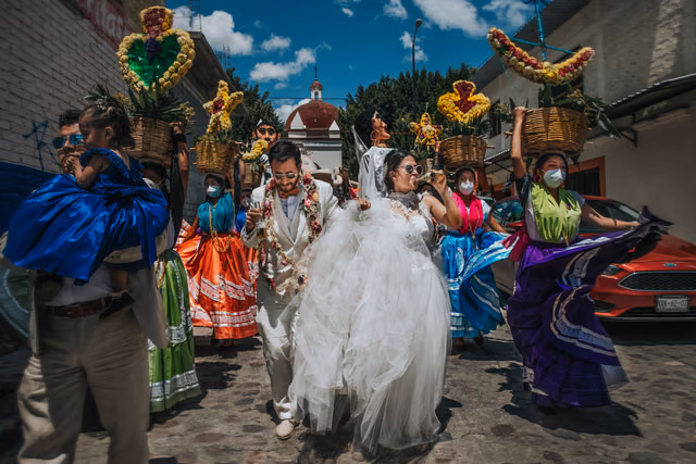 Evelyn y Antonio en su boda en Mitla, Oaxaca, acompañados por la comparsa