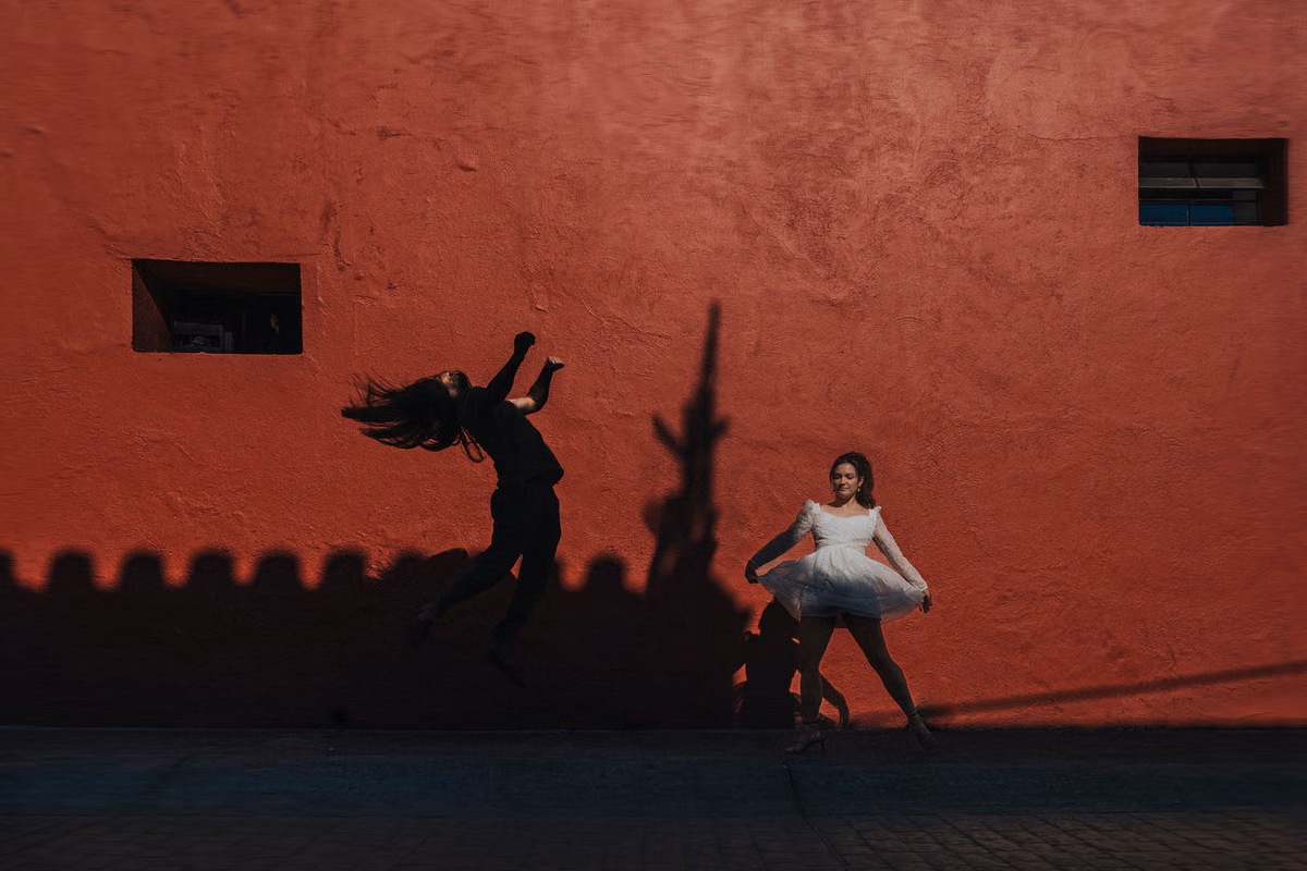 Una pareja bailando frente a una pared roja en Tlaquepaque, Jalisco, en una sesión preboda